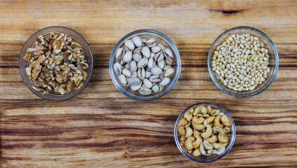 bowls with nuts on wooden background