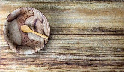wooden spoon in a wooden bowl on wooden background