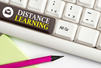 Conceptual hand writing showing Distance Learning. Concept meaning educational lectures broadcasted over the Internet remotely Colored keyboard key with accessories arranged on empty copy space