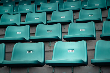 Row of green color seating chair in at sport stadium, close-up and selective focus. Sport object/background pattern photo.