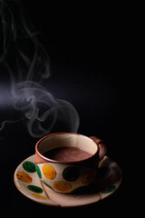 Hot cocoa in vintage ceramic cup on black background