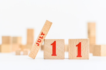 11th of July on the wooden calendar blocks on white background.