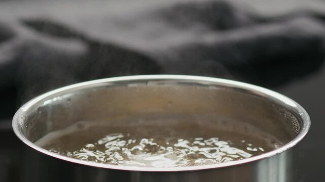 Slow motion closeup of boiling fusilli in a saucepan