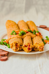 Gluten-free keto Crepes filled with paprika hummus in the oven with curry sauce and sweet corn and green peas on top