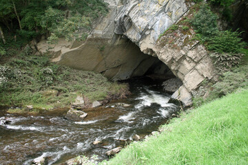 l'entrée d'une caverne où pénètre une rivière