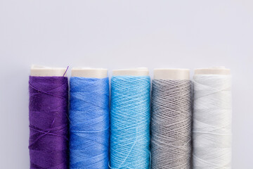 Skeins of blue thread on a gray background. Sewing machine threads. Materials for sewing.