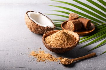Granular and block shape of organic brown palm sugar on grey concrete background.