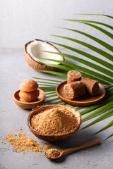 Different shape of organic brown palm sugar on grey concrete background.