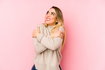 Middle age woman over isolated background hugs, smiling carefree and happy.