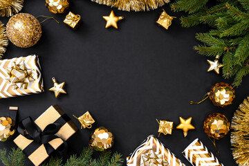 Christmas decoration on dark background. Shiny golden Christmas gifts and golden decorations on black background. Flat lay composition for new year, xmas, christmas.