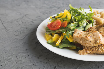 Fresh vegetables salad, cooked turkey breast and whole wheat pasta. Healthy and balanced meal