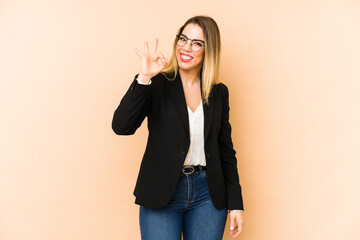 Middle age business woman isolated on beige background cheerful and confident showing ok gesture.