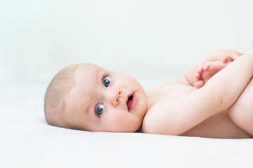 Cute baby girl lying on bed