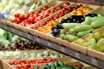 The grocery store sells various vegetables, tomatoes, cucumbers, eggplants, peppers, zucchini.