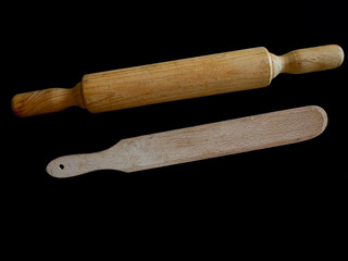 Espátula y rodillo de madera para cocinar , sobre fondo negro. 