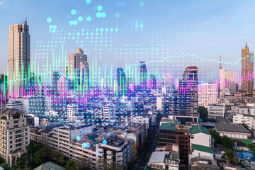 Financial stock chart hologram over panorama city view of Bangkok, business center in Asia. The...