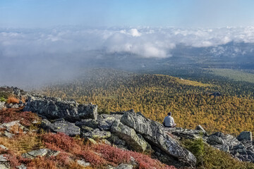 Unrecognizable Male Tourist Enjoying the View over Colorful Forest Valley from Rocky Mountain in Autumn. Basegi Nature Reserve, the Urals, Russia