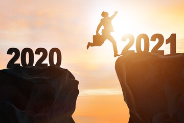 Businessman jumping from the year 2020 to 2021