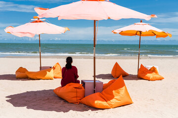 Obraz premium Woman relax on seat under parasol on summer beach