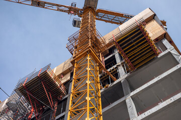 dźwig budowlany na tle budynku w mieście © FOTOWAWA