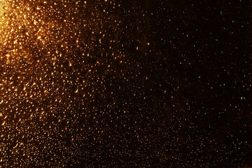 Fototapeta na wymiar Water drops on a window glass after the rain. Gold sunset or sunrise on dark background.