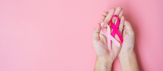 October Breast Cancer Awareness month, adult Woman hand holding Pink Ribbon on pink background for supporting people living and illness. International Women, Mother and World cancer day concept - obrazy, fototapety, plakaty