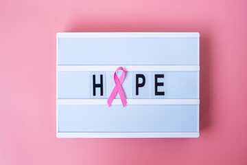 October Breast Cancer Awareness month, Pink Ribbon on lightbox with HOPE text background for supporting people living and illness. International Women, Mother and World cancer day concept