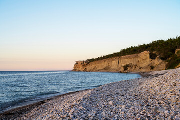 Fototapeta na wymiar Stone beach with chalk cliff background