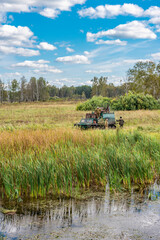 Fototapeta premium Hunters and an old military tracked tractor built in the 70s of the last century in the Soviet Union on a hunting trip in the autumn forest