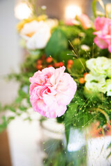 Pale pink peony in a bunch of beautiful pastel flowers, close up and focus on one flower.