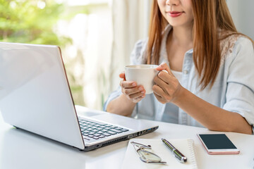 Young woman taking a coffee break and relaxing at living room while working at home, Work from home concept