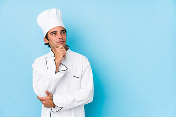 Young cook man isolated looking sideways with doubtful and skeptical expression.