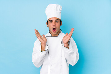 Young cook man isolated surprised and shocked.