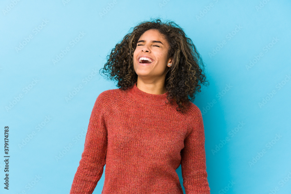 Wall mural young african american curly hair woman relaxed and happy laughing, neck stretched showing teeth. - Wall murals