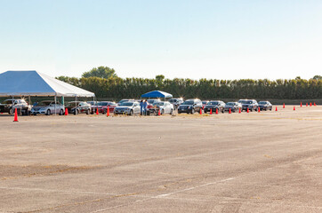 A line of cars waiting in a parking lot at a free Covid-19 testing site.