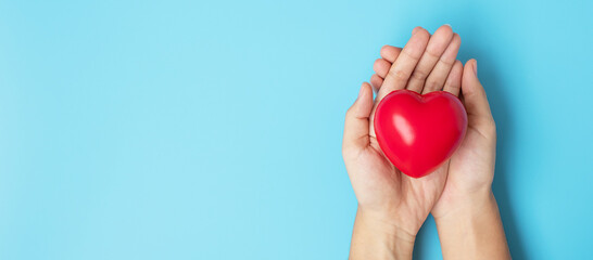 Woman holding Red heart shape on blue background. Healthcare, life Insurance, health and World Heart Day concept
