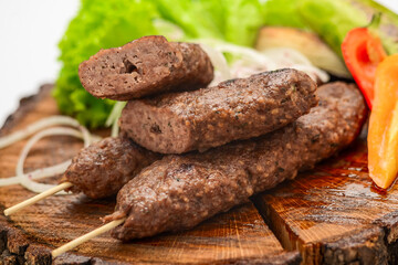 Lamb kebabs on serving board with vegetables