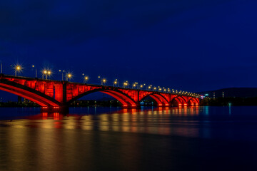 Fototapeta na wymiar Beautiful illumination of the bridge in the evening and at night creates a sense of celebration even in bad weather