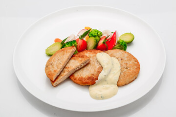 schnitzel, chicken cutlet with white sauce and vegetables