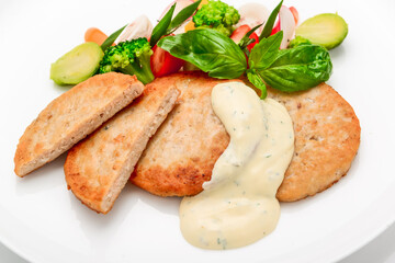 schnitzel, chicken cutlet with white sauce and vegetables