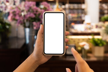 Woman hand's holding empty screen mobile phone at the cafe.