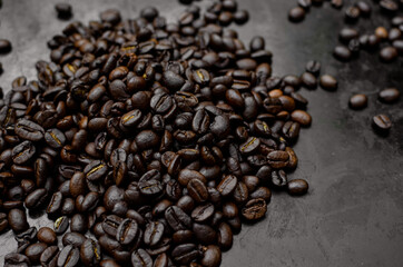 cup of black coffee on black background with roasted coffee beans