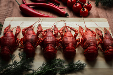 Crawfish on a chopping Board with cherry tomatoes chili peppers and herbs