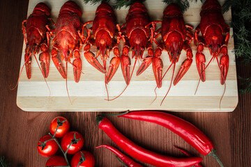 Crawfish on a chopping Board with cherry tomatoes chili peppers and herbs