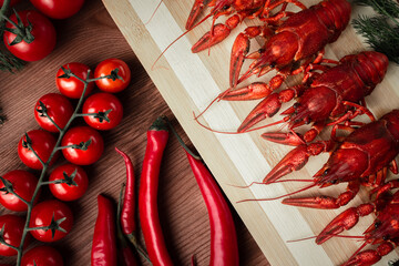 Steamed boiled crawfish on a chopping Board. Crayfish with herbs pepper and tomatoes