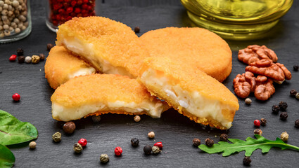 Fried brie cheese in batter on a black stone board