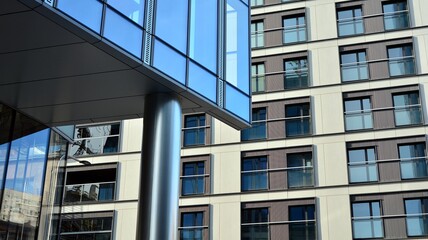 Fototapeta premium Blue curtain wall made of toned glass and steel constructions under blue sky. A fragment of a building.