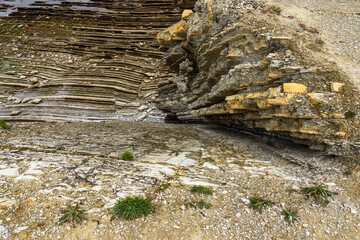 shoreline with rows of rocks in vertical strata on the shoreline on the French atlantic coast