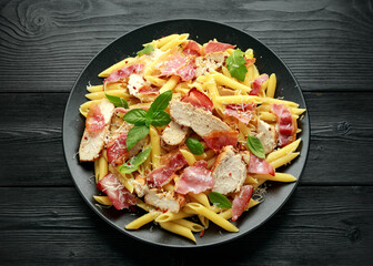 Chicken, bacon Penne pasta with parmesan cheese and basil. healthy food.