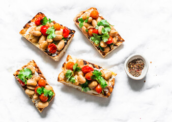 Goats cheese crostini with garlicky beans on a white background, tp view
